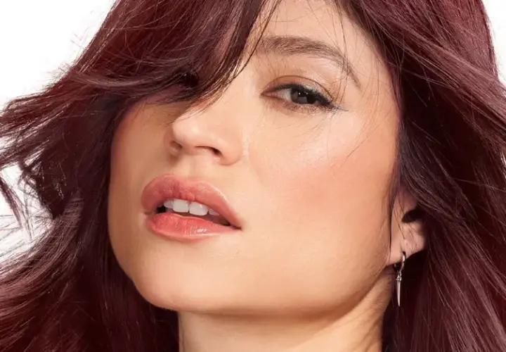 Mujer con un vibrante **cherry pelo** que enmarca su rostro, con labios jugosos y una mirada cautivadora.