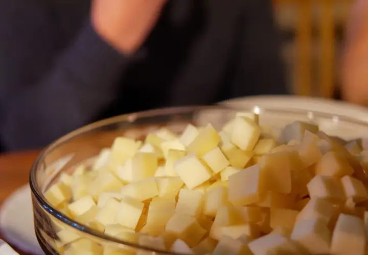 Un bol rempli de dés de fromage savoyard, prêt à être fondu pour un plat réconfortant.