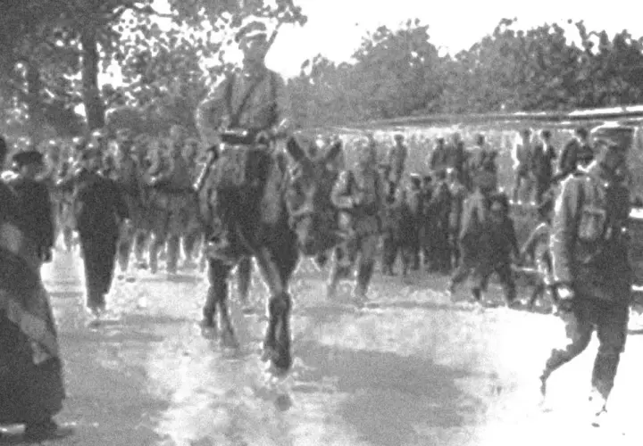 Żołnierze w historycznych mundurach, w tym na koniu, maszerują w zwartym szyku. To widok nawiązujący do czasów, gdy formowały się legiony polskie.