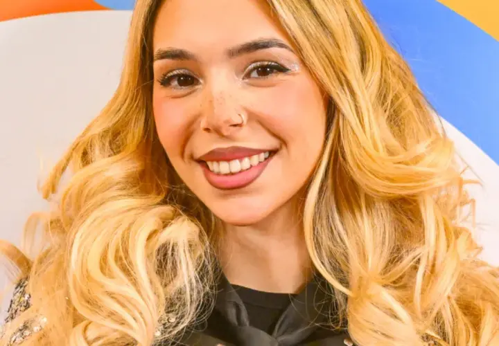 Uśmiechnięta młoda kobieta z blond włosami i piegami.
