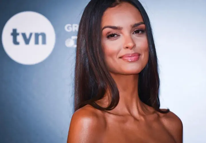 Klaudia El Dursi, top model, uśmiecha się na tle logo TVN.