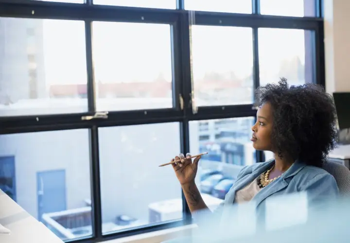 A woman ponders her future, perhaps considering a public administration degree to shape policy and improve communities.