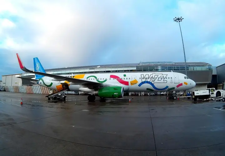 Samolot Wizz Air z kolorowym malowaniem na płycie lotniska.