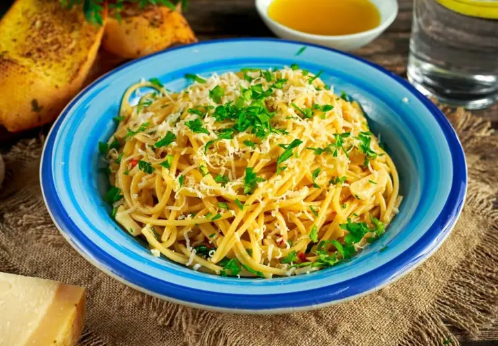 Aglio olio z parmezanem i natką pietruszki, podane z grzankami czosnkowymi.
