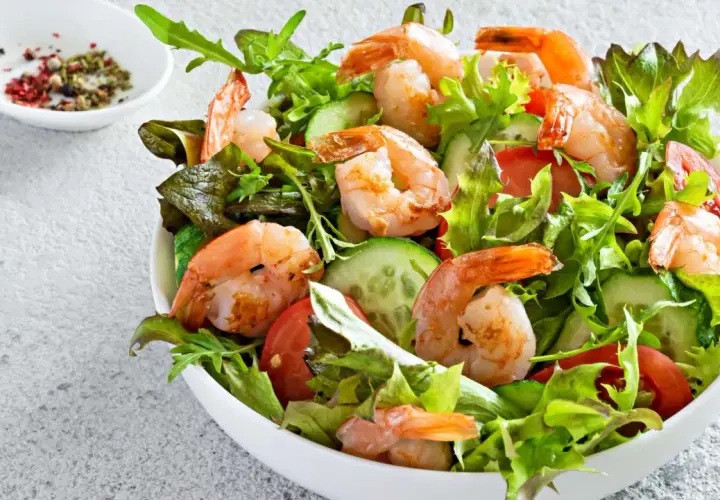 Deliciosa ensalada de langostinos con lechugas frescas, tomate y pepino. Un plato ligero y lleno de sabor.