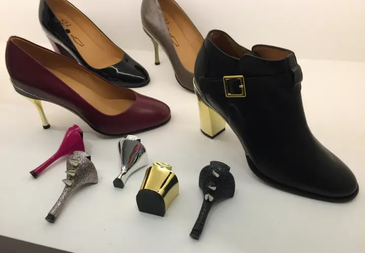 Buty z wymiennymi obcasami: czarne botki, bordowe i czarne szpilki, szare czółenka oraz ozdobne obcasy.