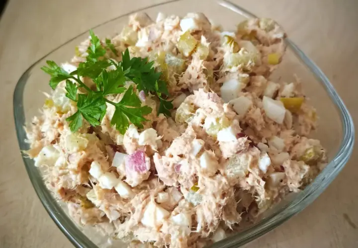 Pyszna pasta z tuńczyka i jajka, z dodatkiem ogórka kiszonego i cebuli, udekorowana natką pietruszki. Idealna na kanapki.