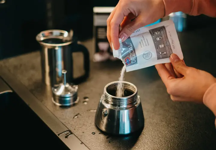 Wsypywanie proszku do czyszczenia kawiarki. Czyszczenie kawiarki sodą to świetny sposób na jej odświeżenie.