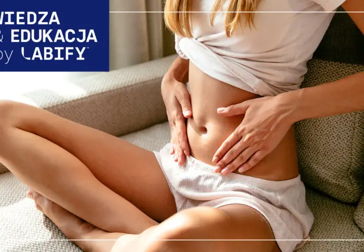 Kobieta trzyma się za brzuch, szukając ulgi co na gazy. Wiedza i edukacja by Labify.