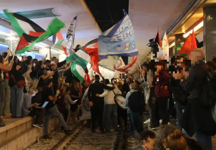 Folla in piazza a Roma per uno sciopero venerdì, sventolano bandiere palestinesi e altri vessilli.