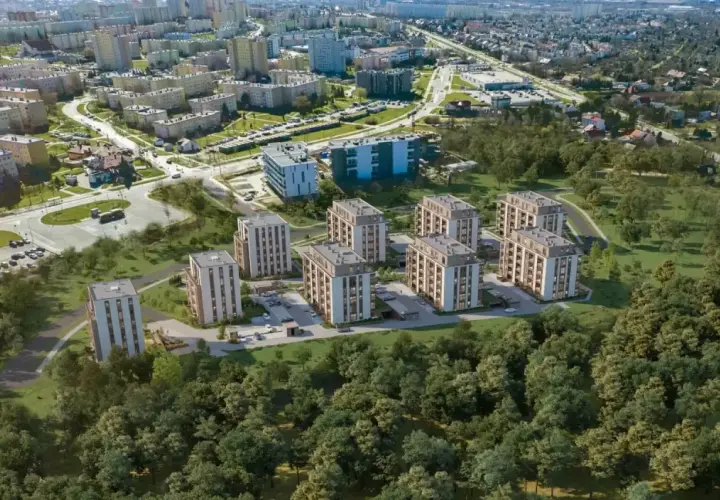 Nowe inwestycje w Kielcach: nowoczesne bloki mieszkalne otoczone zielenią, w tle widoczne osiedla i droga.