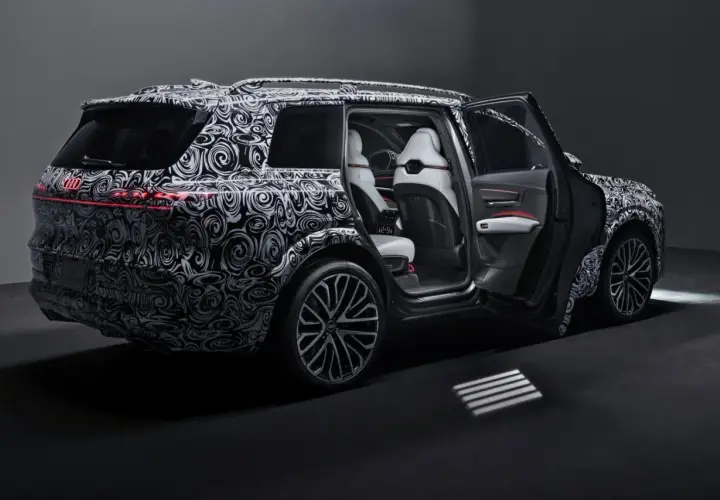 Nowy Audi Q9 w kamuflażu, z otwartymi drzwiami, prezentuje luksusowe wnętrze. Czekamy na jego cenę i premierę!