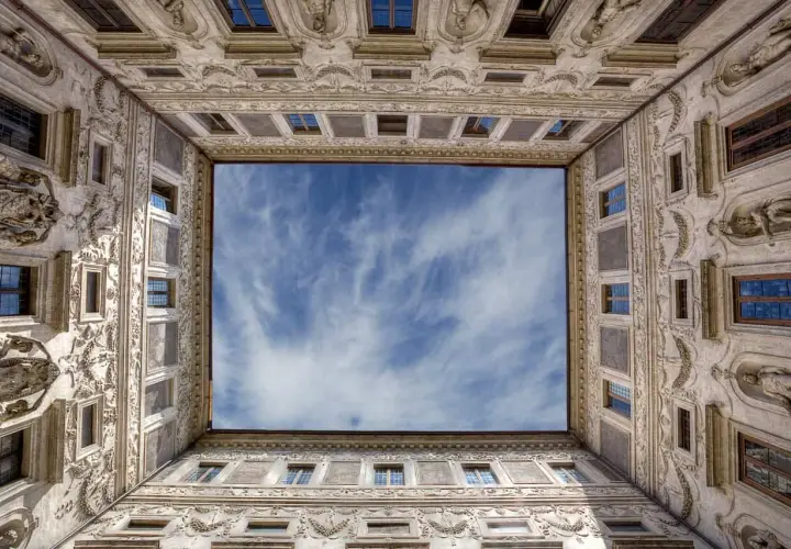 La galleria Borromini, con la sua prospettiva unica, incornicia un cielo azzurro e nuvoloso.