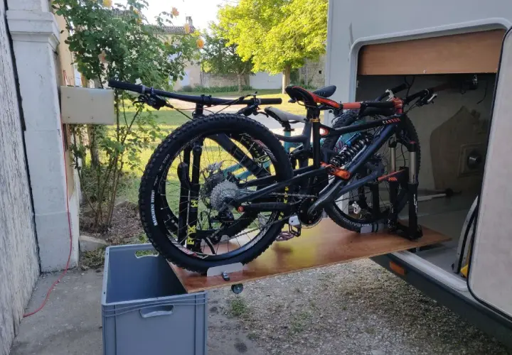 Plateforme DIY pour fabriquer un porte vélo de soute, avec deux VTT prêts à être rangés.