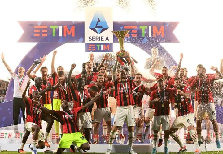 Piłkarze świętują zdobycie scudetto, unosząc puchar Serie A wśród konfetti i fajerwerków.