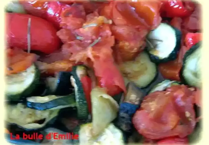 Un plat coloré de ratatouille au four, avec des rondelles de courgettes, des poivrons rouges et des tomates. Un délice provençal !