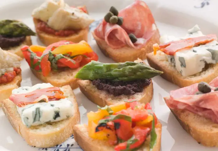 Variedad de crostini italiano: con salami, queso azul, espárragos, tomates y aceitunas.