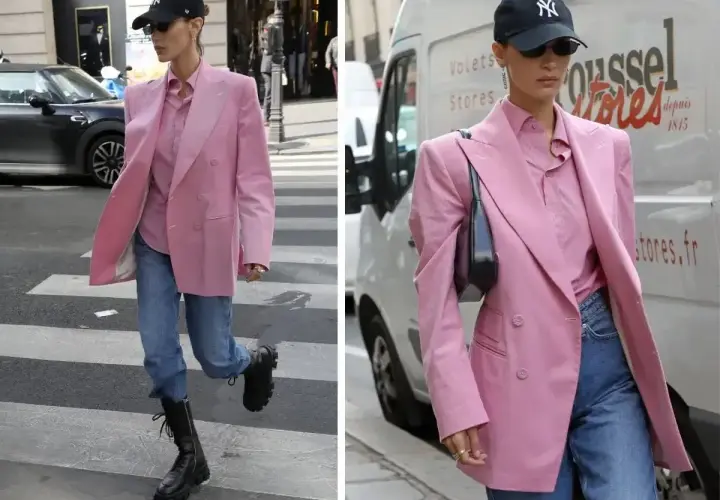 Kobieta w marynarce w odcieniu **magenta kolor** i jeansach idzie ulicą.