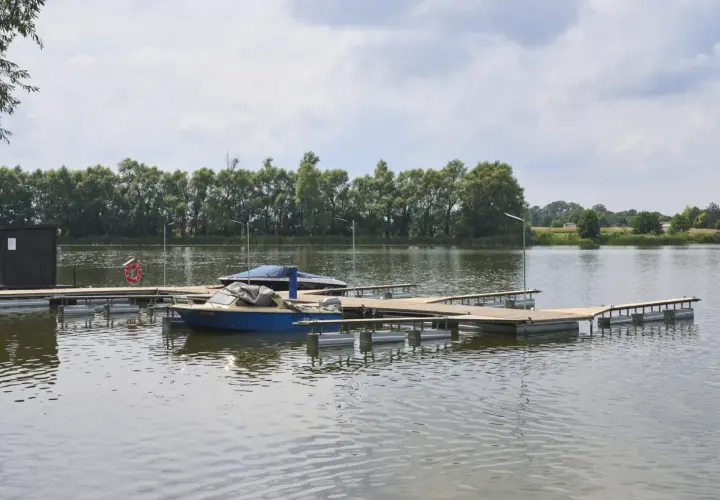 Drewniany pomost na stawie, idealny do cumowania łodzi. Zastanawiasz się, jak zrobić pomost na stawie? Oto przykład.