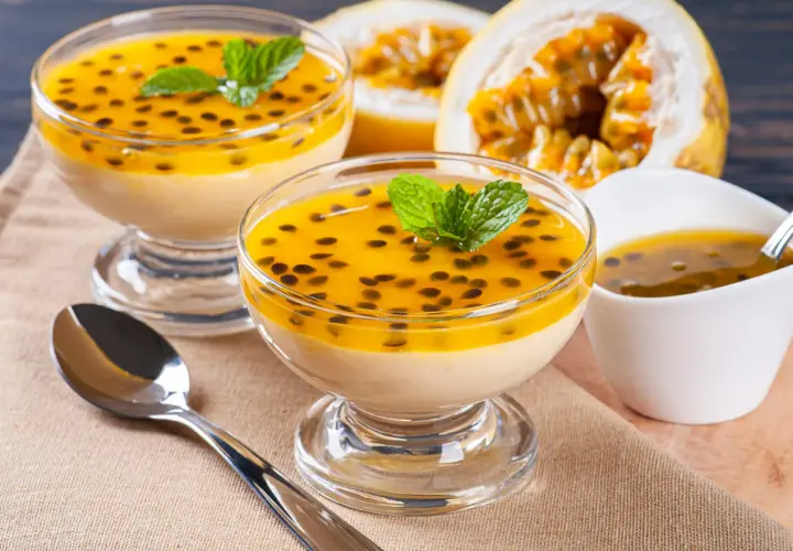 Douceur tropicale : deux coupes de mousse onctueuse, garnies de fruits de la passion et de menthe, un délice de dessert brésilien.