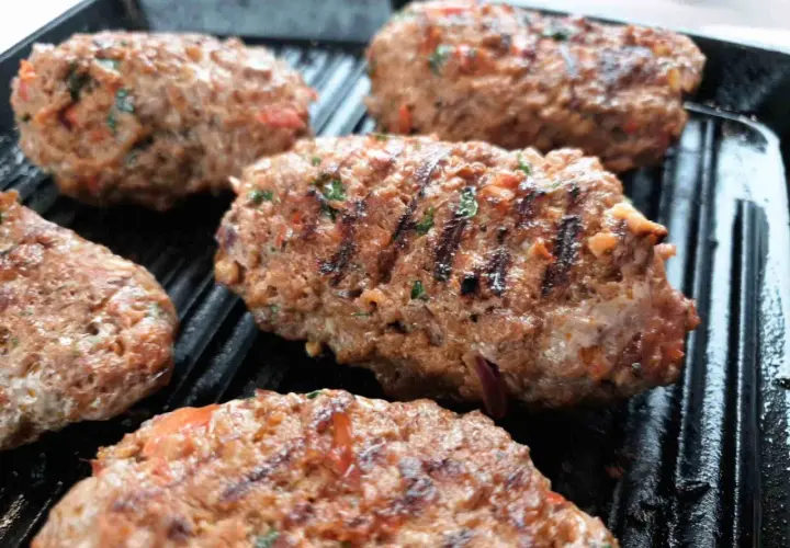 Soczyste Adana kebab w trakcie grillowania. Idealny przepis na pyszny obiad.