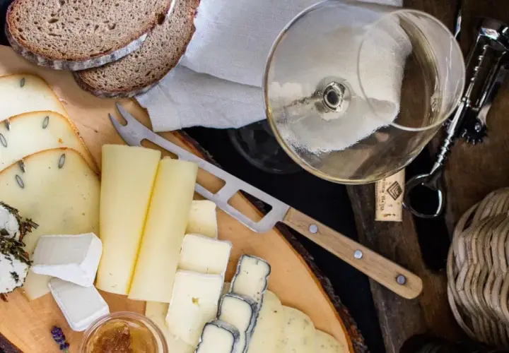 Deska serów z chlebem i kieliszkiem wina, idealna do degustacji Bardolino Chiaretto.