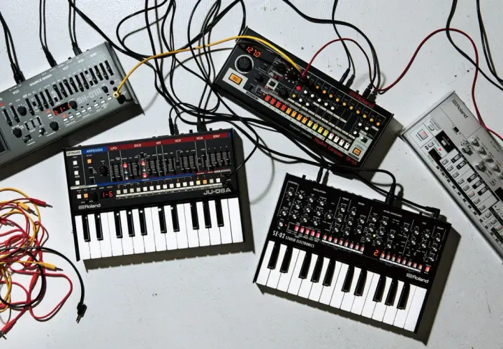 Ensemble de matériel pour composer musique électronique : synthétiseurs, boîtes à rythmes et câbles.