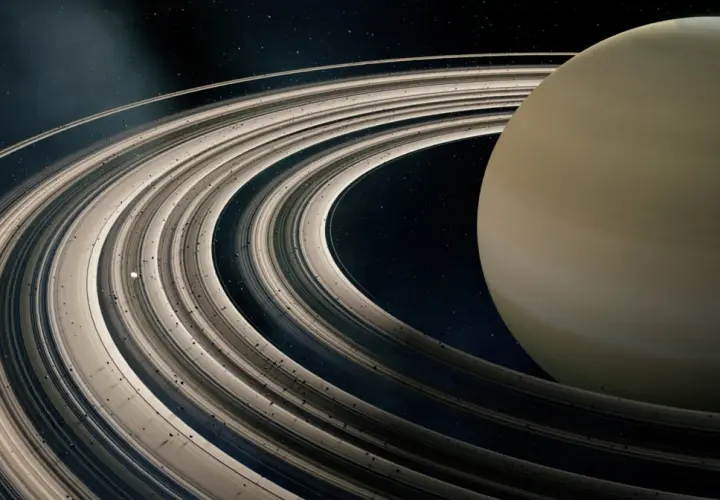 Majestatyczne pierścienie planet otaczają gazowego giganta. W oddali widać mały księżyc.