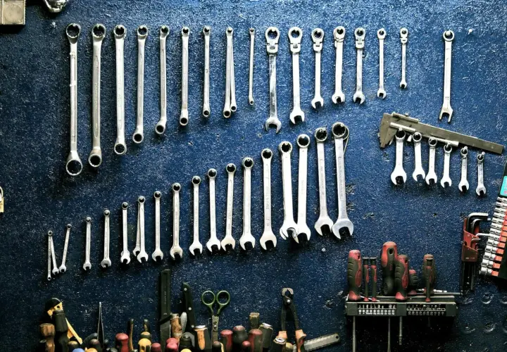 Un mur de garage bleu orné de clés à molette et d'outils divers, rappelant le droit de rétention du garage.
