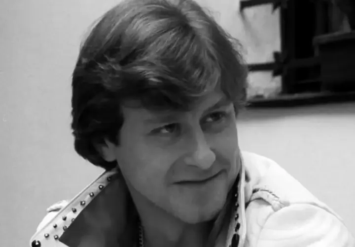 Uśmiechnięty mężczyzna w skórzanej kurtce z ćwiekami, kadr z filmu "Tulipan".