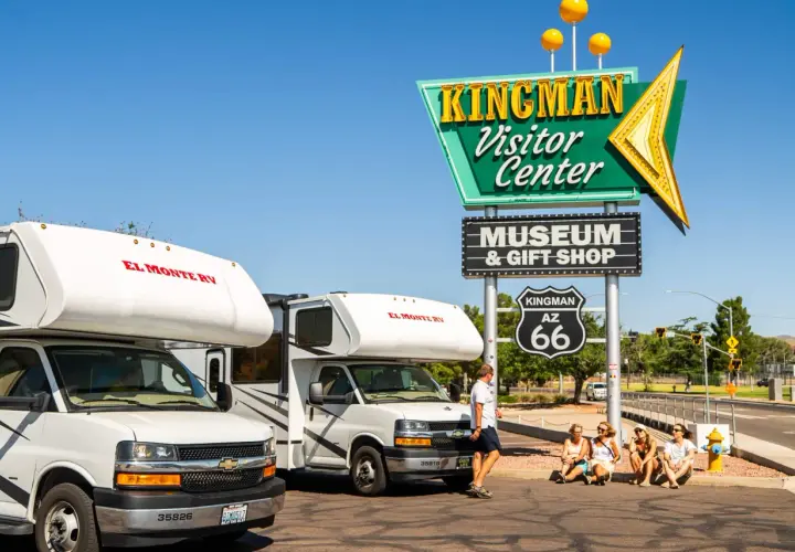 Dwa kampery El Monte RV przy znaku Kingman Visitor Center na Route 66.