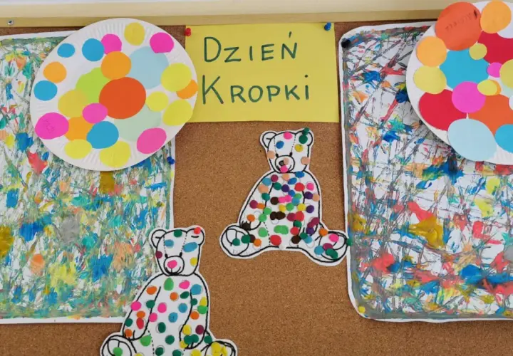 Kolorowe misie i talerzyki z kropkami ozdabiają tablicę z napisem "Dzień Kropki". Prace plastyczne pełne radości i barw.
