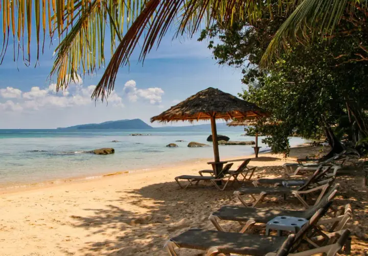 Sonniger Strand in Kambodscha, ein echter Geheimtipp. Liegestühle und Sonnenschirme laden zum Entspannen ein.