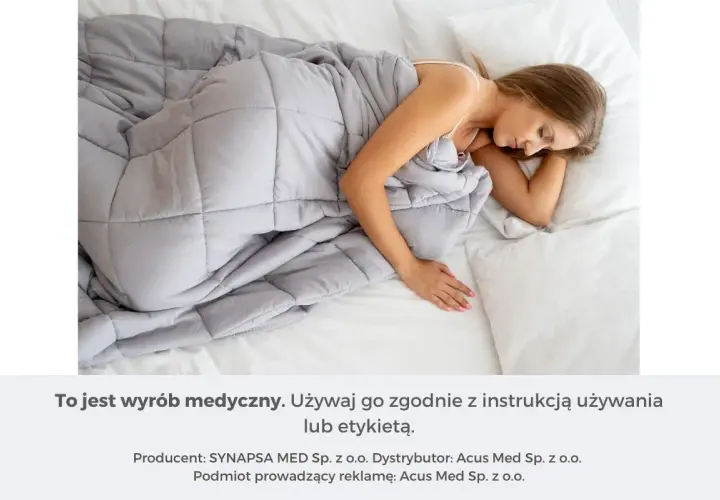 Kobieta śpi pod szarą kołdrą obciążeniową. Dowiedz się, jak dobrać idealną kołdrę obciążeniową dla siebie.