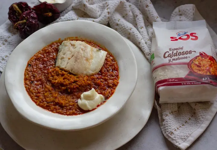 Un plato de caldero murciano con pescado y un toque de alioli, acompañado de arroz especial caldoso y pimientos secos.