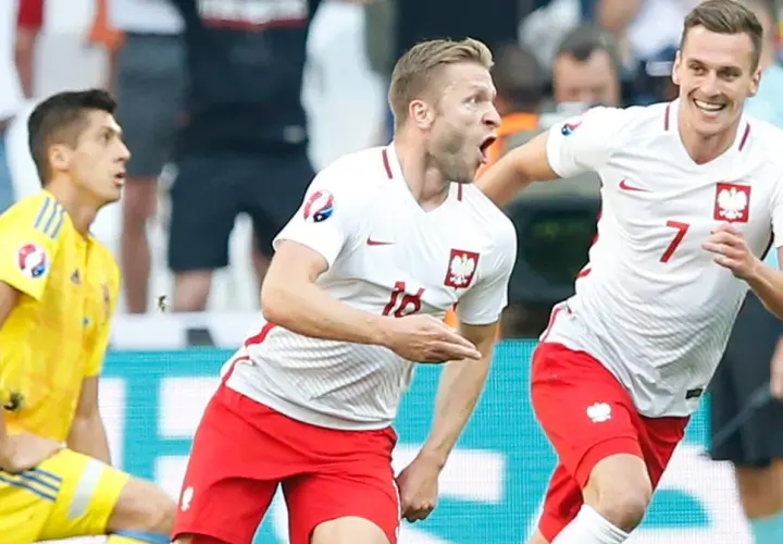 Piłkarze Polski świętują zwycięstwo nad Ukrainą na Euro. Radość na twarzach, biało-czerwone barwy.