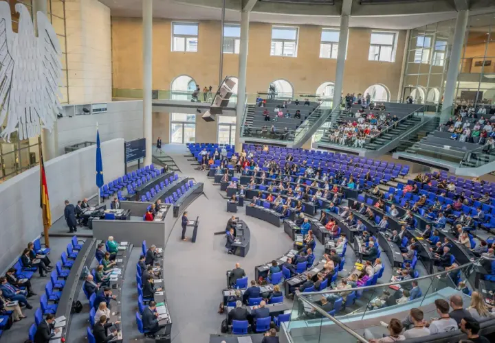 Der Bundestag im Plenum, bereit für einen Hammelsprung. Viele Abgeordnete sitzen auf ihren Plätzen, andere stehen.