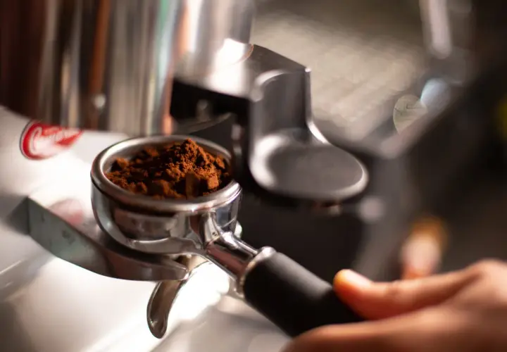 Portafiltro con macinatura caffè fine, pronto per l'estrazione. Regolare la macinatura caffè come fare per un espresso perfetto.