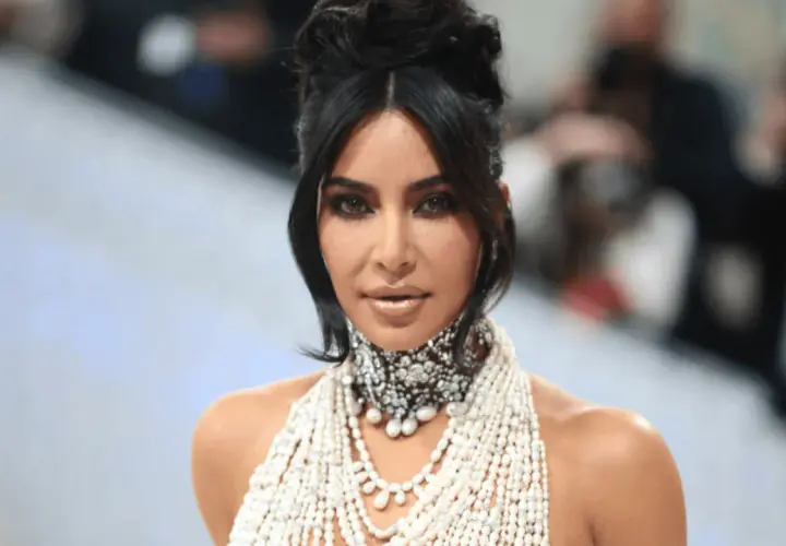 Kim Kardashian na Met Gali w olśniewającej kreacji z pereł i kryształów, z charakterystyczną fryzurą i makijażem.