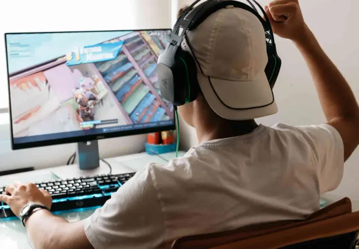 Junge spielt Videospiel, jubelt über Sieg. Er fragt sich, was VSync ist, um Ruckeln zu vermeiden.