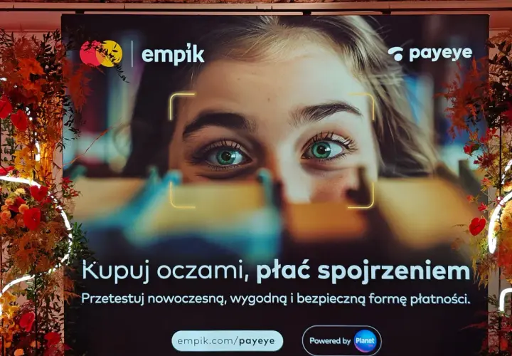 Reklama Empiku z hasłem "Kupuj oczami, płać spojrzeniem". Pokazuje zbliżenie na zielone oczy młodej kobiety, sugerując innowacyjne metody płatności Payeye.