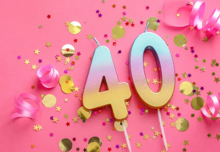 Velas con el número 40, confeti de estrellas y círculos dorados, y cintas rosas sobre fondo rosa. ¡Perfecto para frases 40 cumpleaños originales!