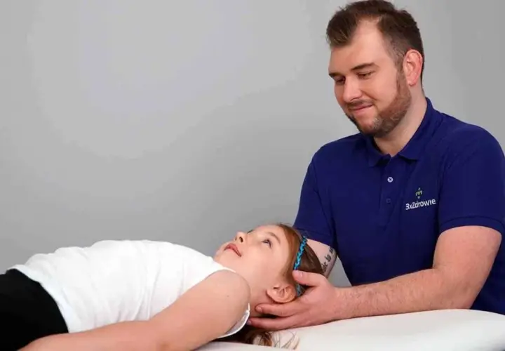 Terapia czaszkowo-krzyżowa pomaga dziecku z depresją. Terapeuta delikatnie dotyka głowy dziewczynki.