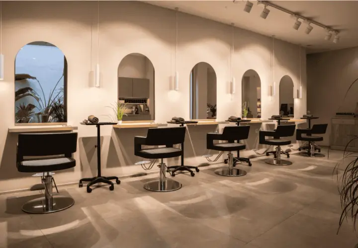 Estilo moderno en peluquería. Sillones negros, espejos arqueados y plantas. Descubre los secretos de agua peluquería para un look radiante.