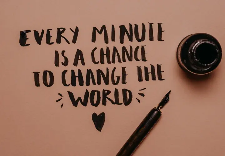 Every minute is a chance to change the world" - frasi motivazionali brevi in inglese scritte a mano con pennino e calamaio.