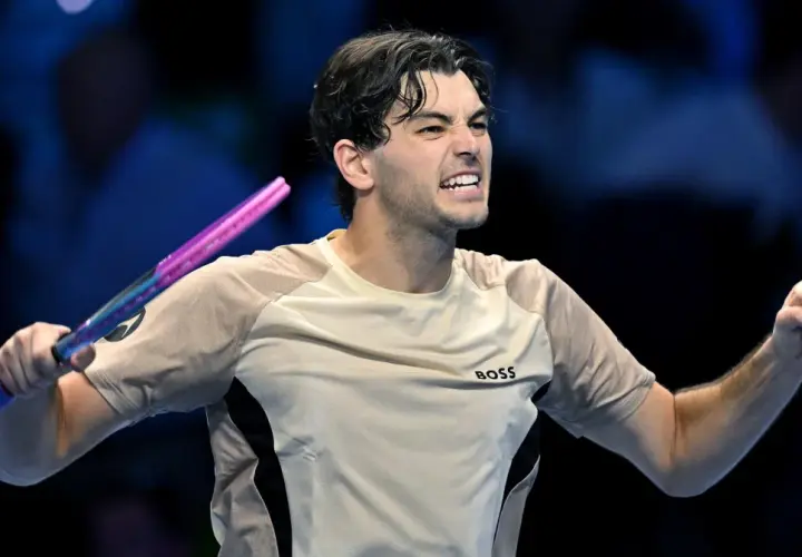Taylor Fritz, tenisista, triumfuje po wygranym punkcie, zaciskając pięść i unosząc rakietę.