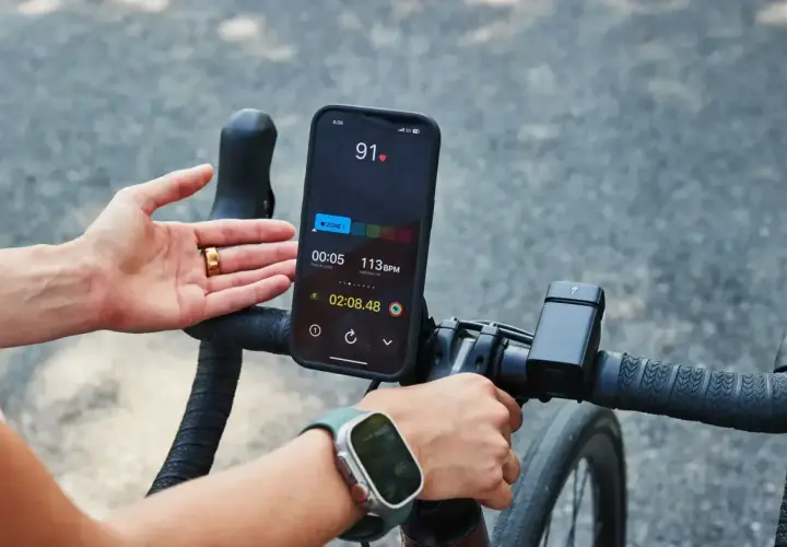 Rowerzysta monitoruje swój puls podczas treningu. Na ekranie telefonu widoczny jest puls 91 BPM, wskazujący na aktywność sportowca.