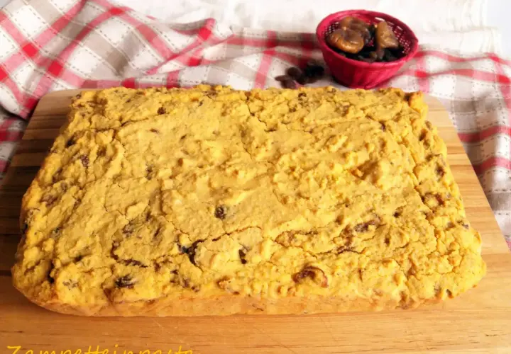 Pincia veneziana, dolce tipico natalizio, con uvetta e fichi secchi, su tagliere di legno.