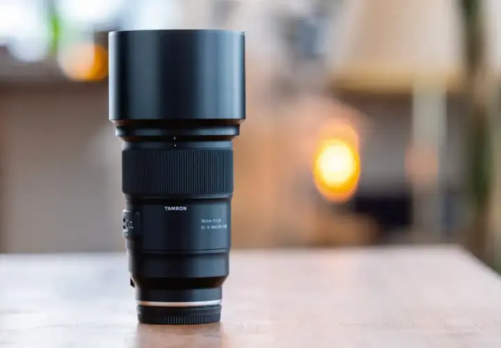 Obiektyw Tamron 90mm f/2.8 Di III MACRO VLD, idealny do fotografii w **trybie makro**, z charakterystycznym pierścieniem ostrości i osłoną przeciwsłoneczną.