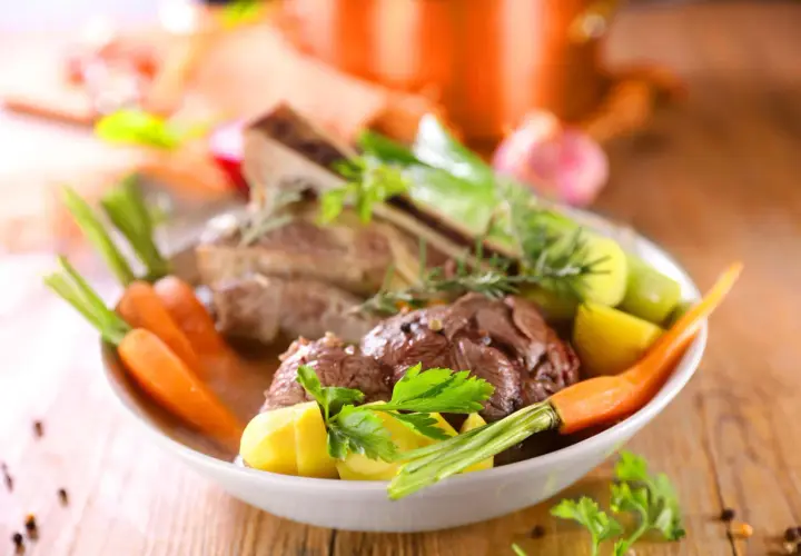 Un plat réconfortant de pot-au-feu, avec du bœuf tendre, des carottes, des pommes de terre et des poireaux, garni de persil frais.